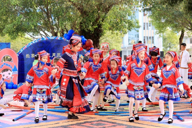 圖4：4月9日，在廣西柳州市融安縣實(shí)驗(yàn)小學(xué)校園，一名老師帶著學(xué)生跳竹竿舞。（譚凱興 攝）.JPG